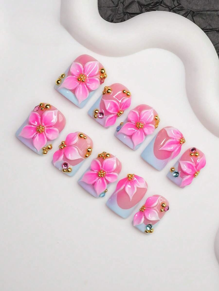 Close view of the 3D hibiscus, gold bead and crystal detail on short square nails