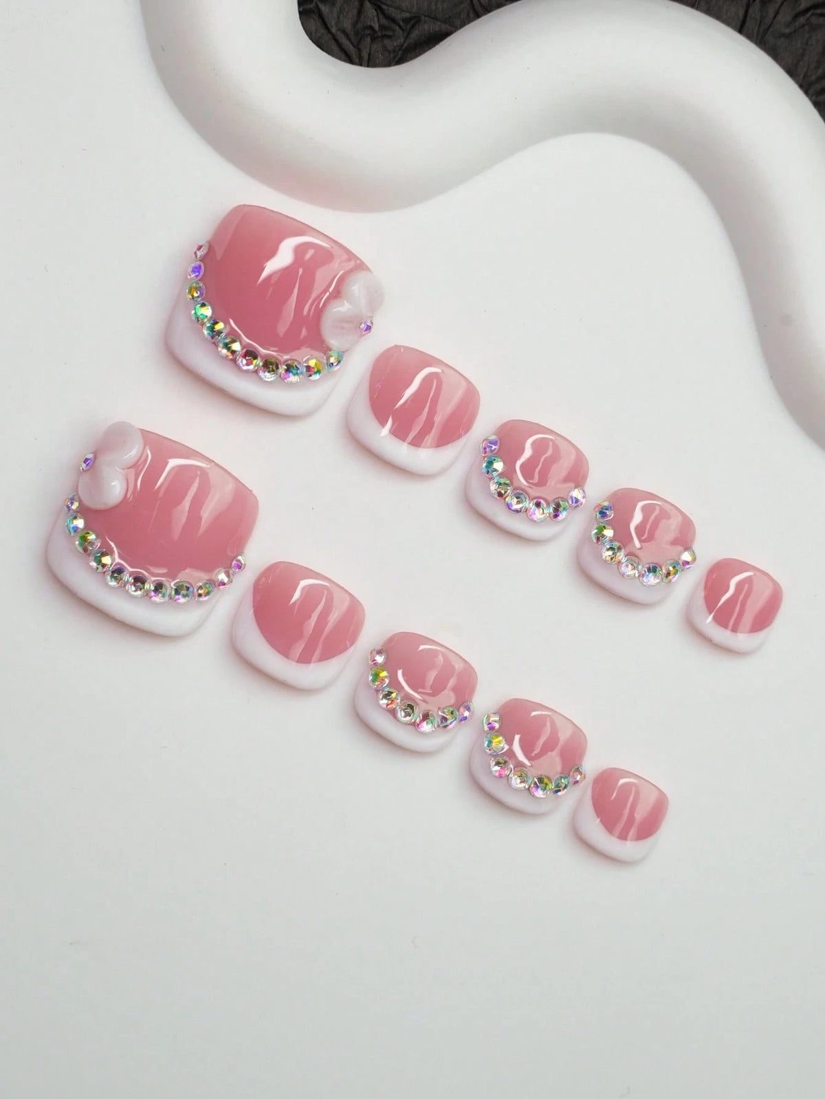 Full set of pink French press-on toenails with 3D bow accents