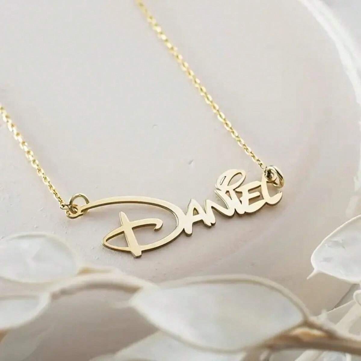 Gold name necklace on a soft background