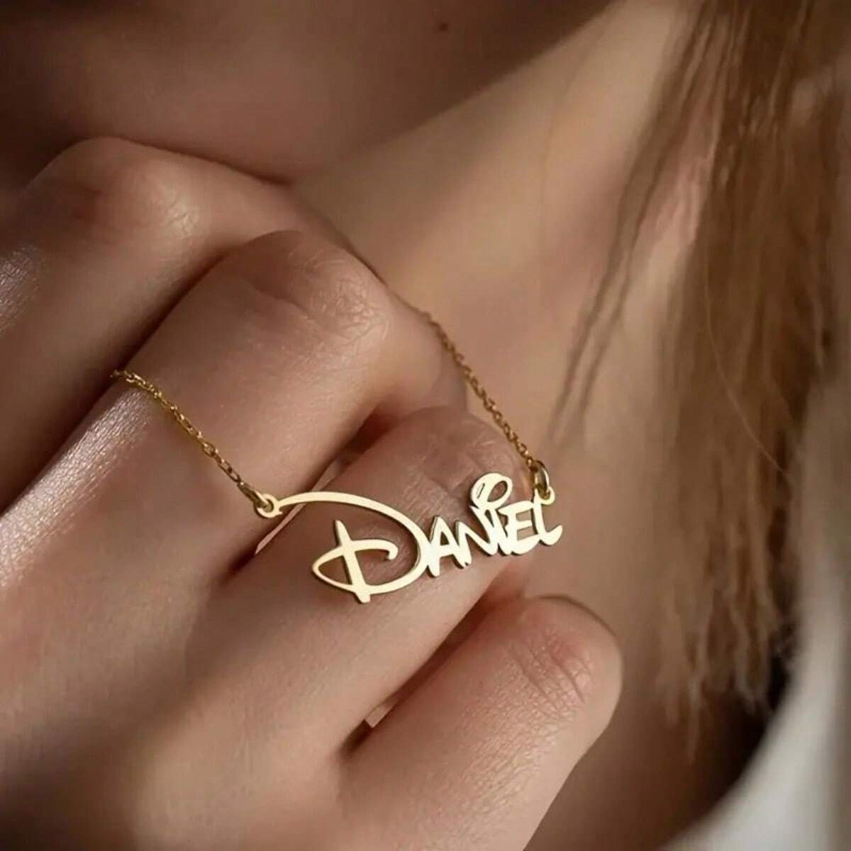 Personalized gold nameplate necklace worn on the collarbone