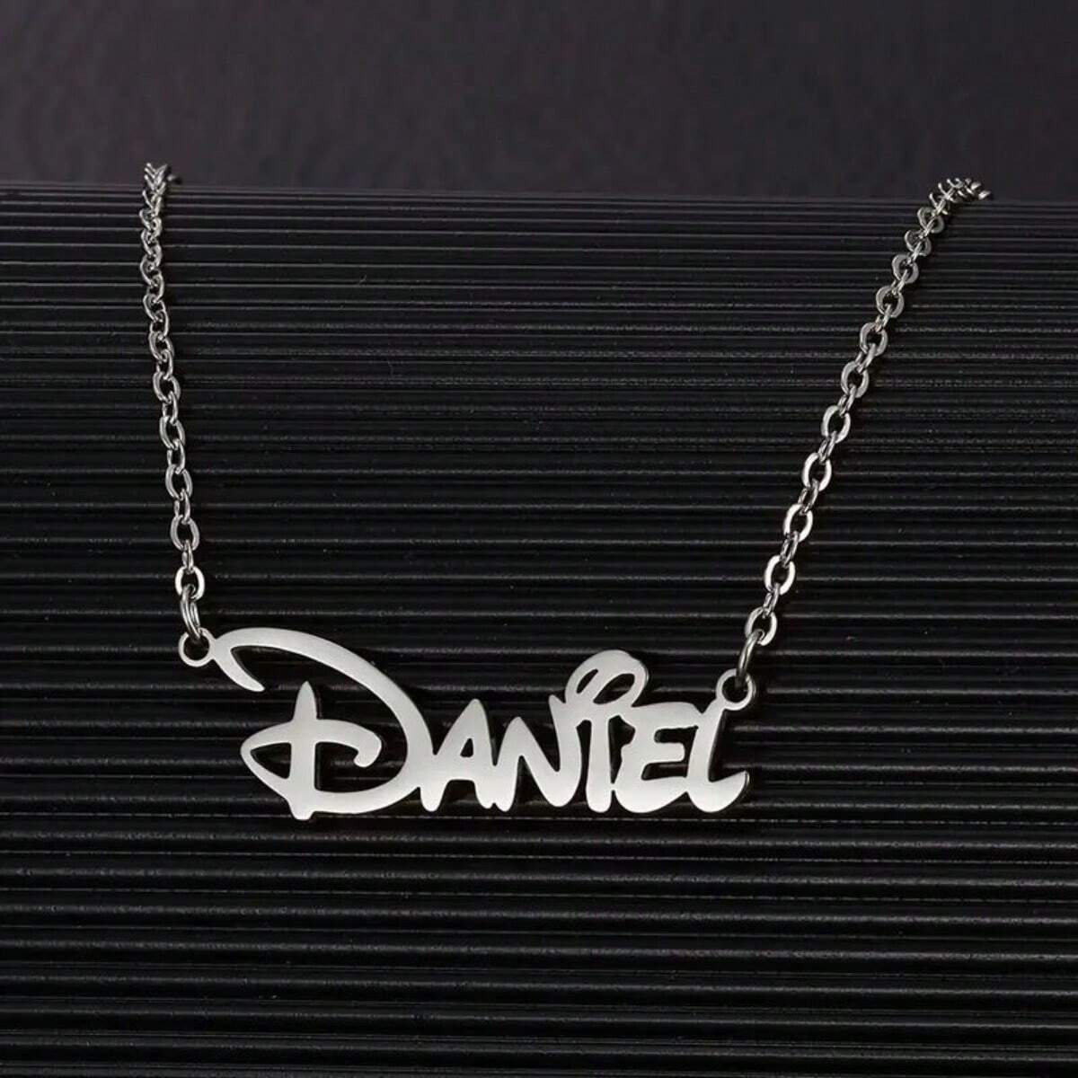Silver personalized name necklace on a dark background