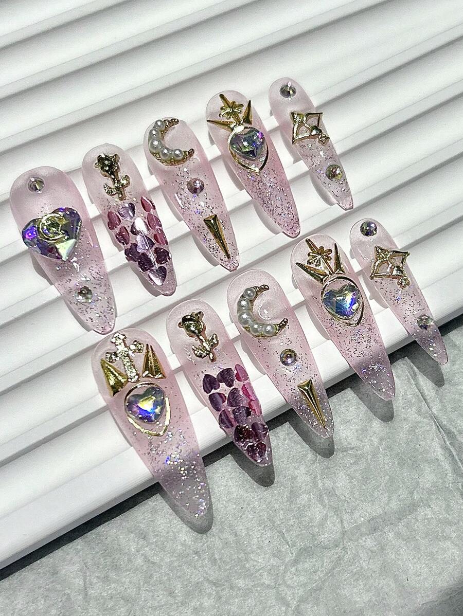 Long stiletto press-on nails in sheer rose glitter with pearl crescents and gold charms