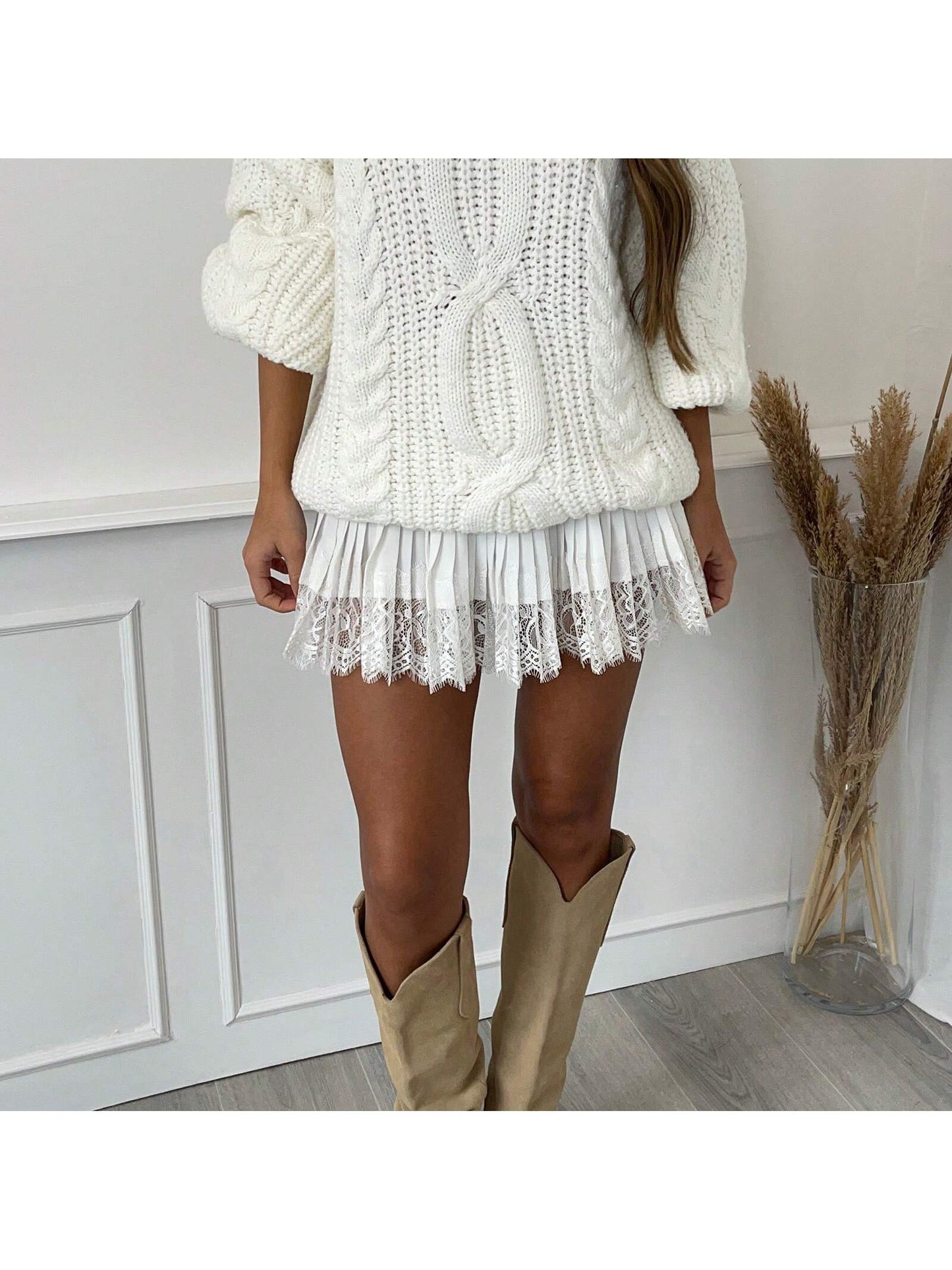 Cream lace mini skirt with a cable knit sweater and boots