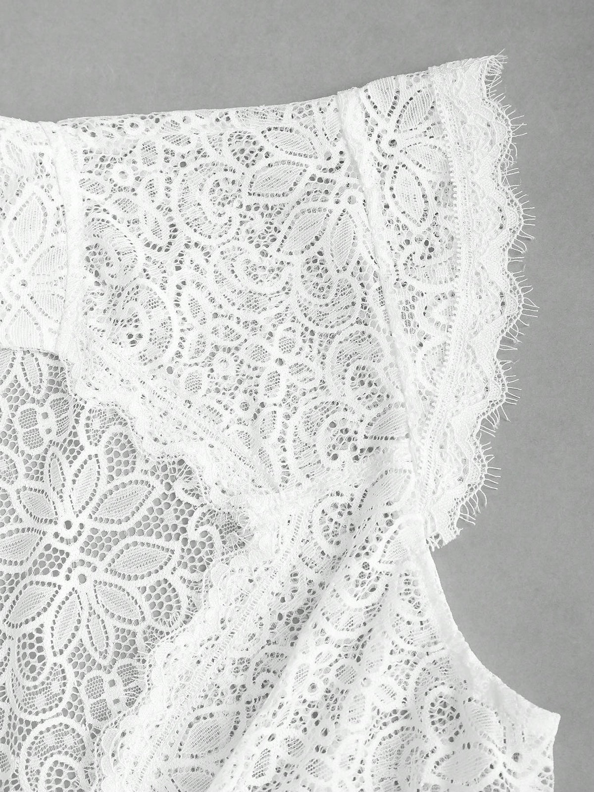 Close-up of the eyelash lace cap sleeve and scalloped trim