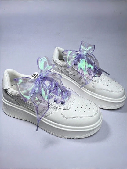 Iridescent lilac ribbon shoelaces tied on white sneakers