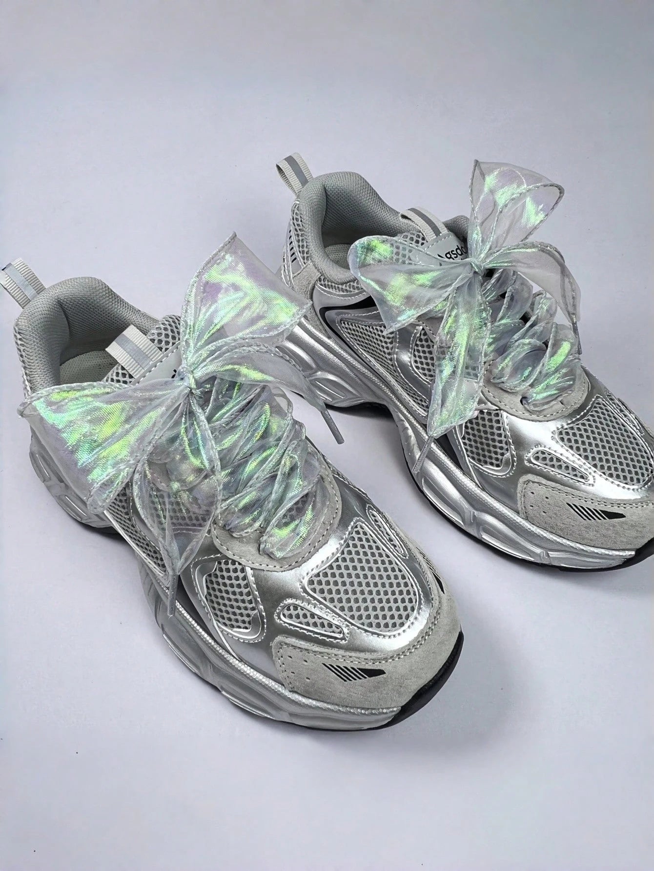 Iridescent ribbon laces on grey and silver trainers
