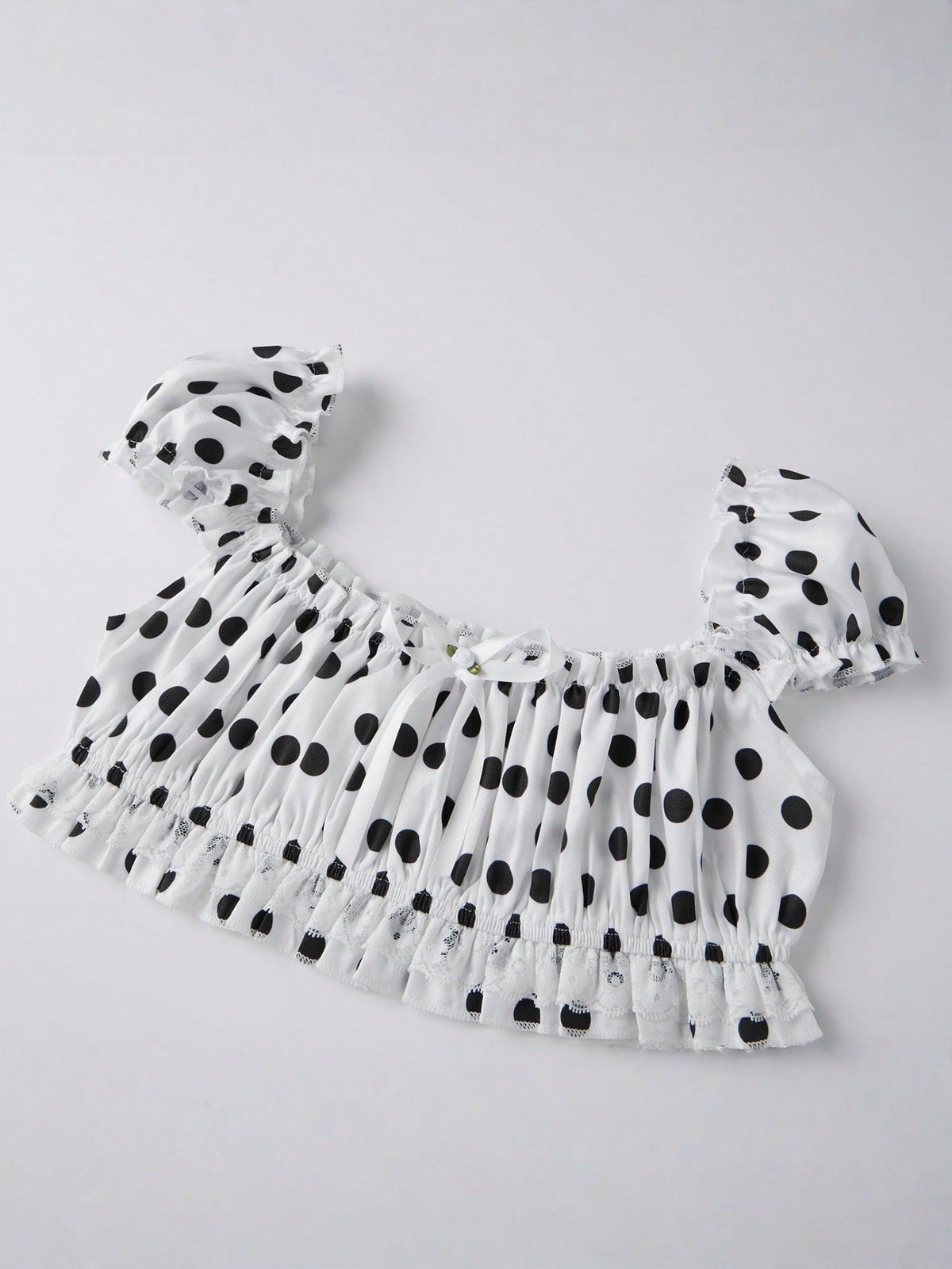 Domino Cream polka dot crop top laid flat, angled