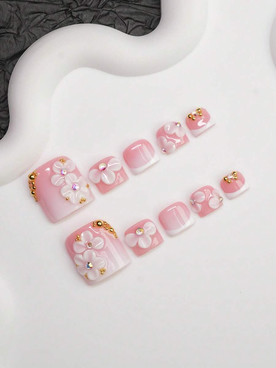 Full set of pink French press-on nails laid out by size