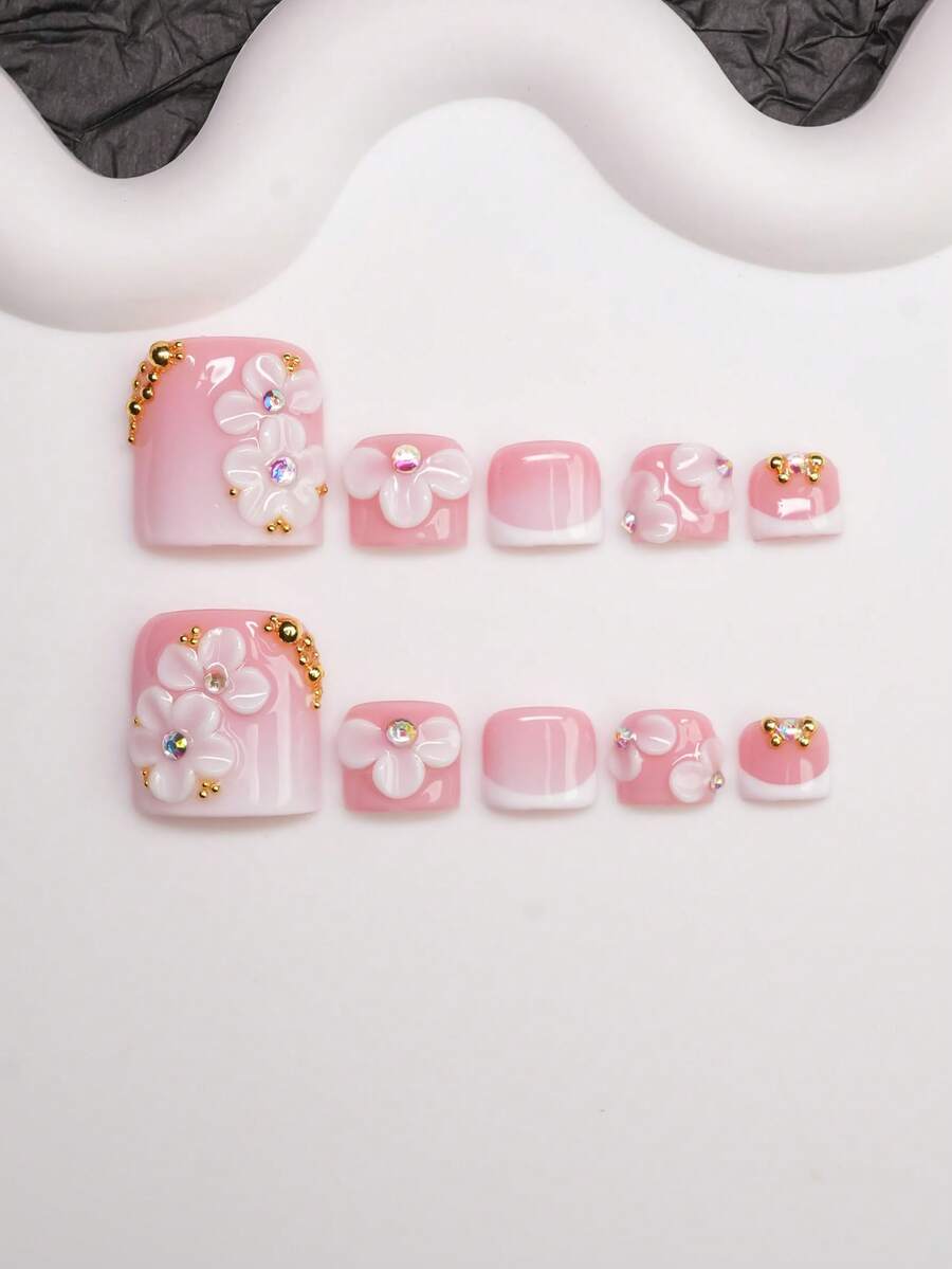 Short square press-on nails in a pink to white French fade with 3D white blossoms and gold beads