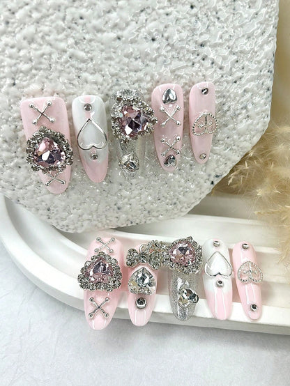 Pink oval press-on nails with heart outlines and silver bow, full set