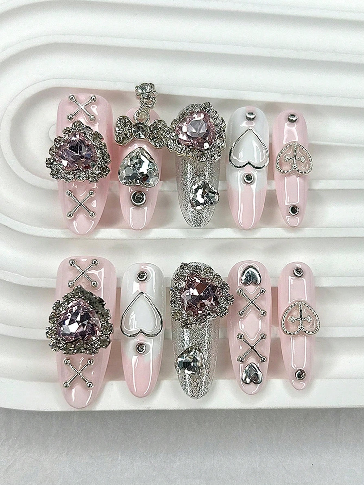 Blush pink long oval press-on nails with pink crystal hearts and silver cross-lace