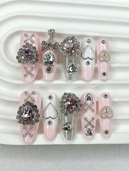 Blush pink long oval press-on nails with pink crystal hearts and silver cross-lace