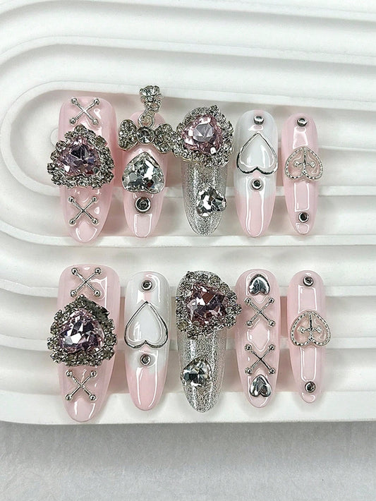 Blush pink long oval press-on nails with pink crystal hearts and silver cross-lace