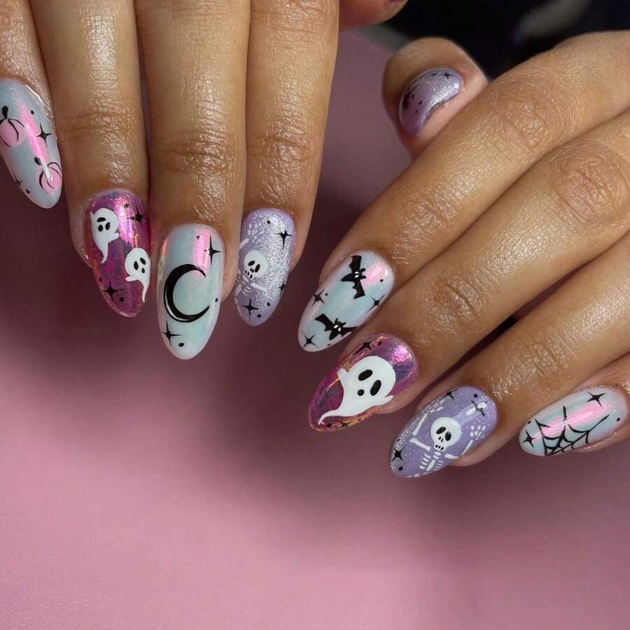 Long almond press-on nails worn on a hand, ghost skull and crescent moon art in lilac and white