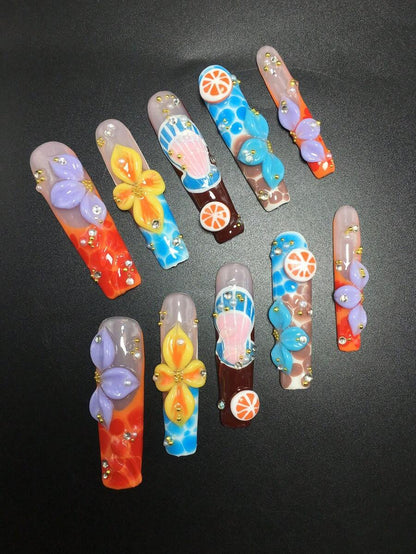 Coffin press-on nails fanned out showing 3D flower and shell charms