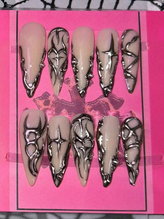 Nude stiletto press-on nails with liquid silver chrome swirls and stars