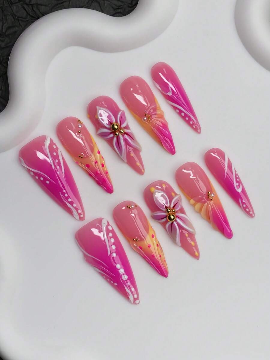 Pink and orange stiletto press-on nails with white swirls shown at an angle