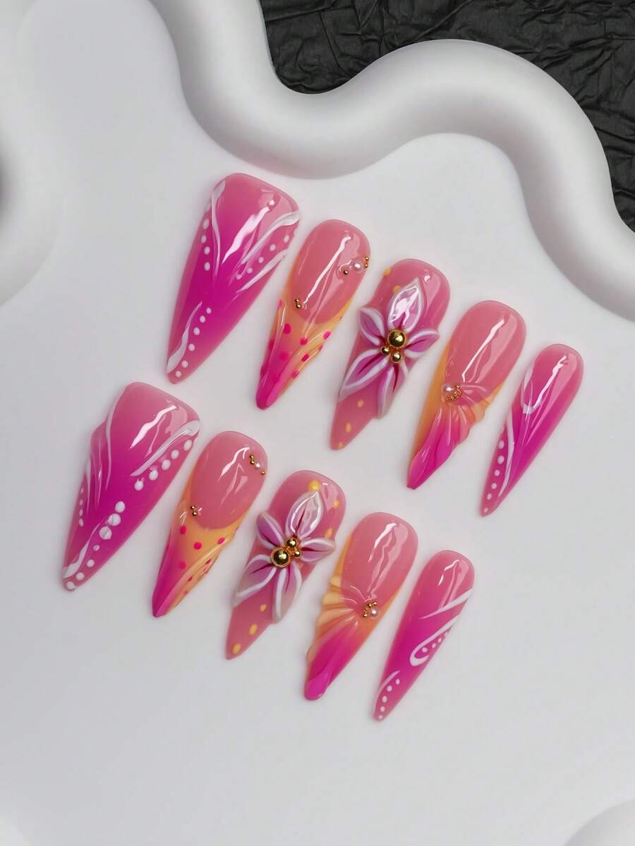 Glossy pink stiletto press-on nails with lily flower and gold bead centers