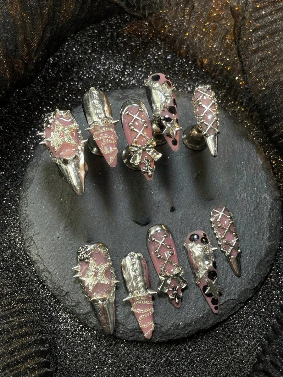 Pink stiletto press-on nails with chrome silver tips, lace chains, spikes and bows