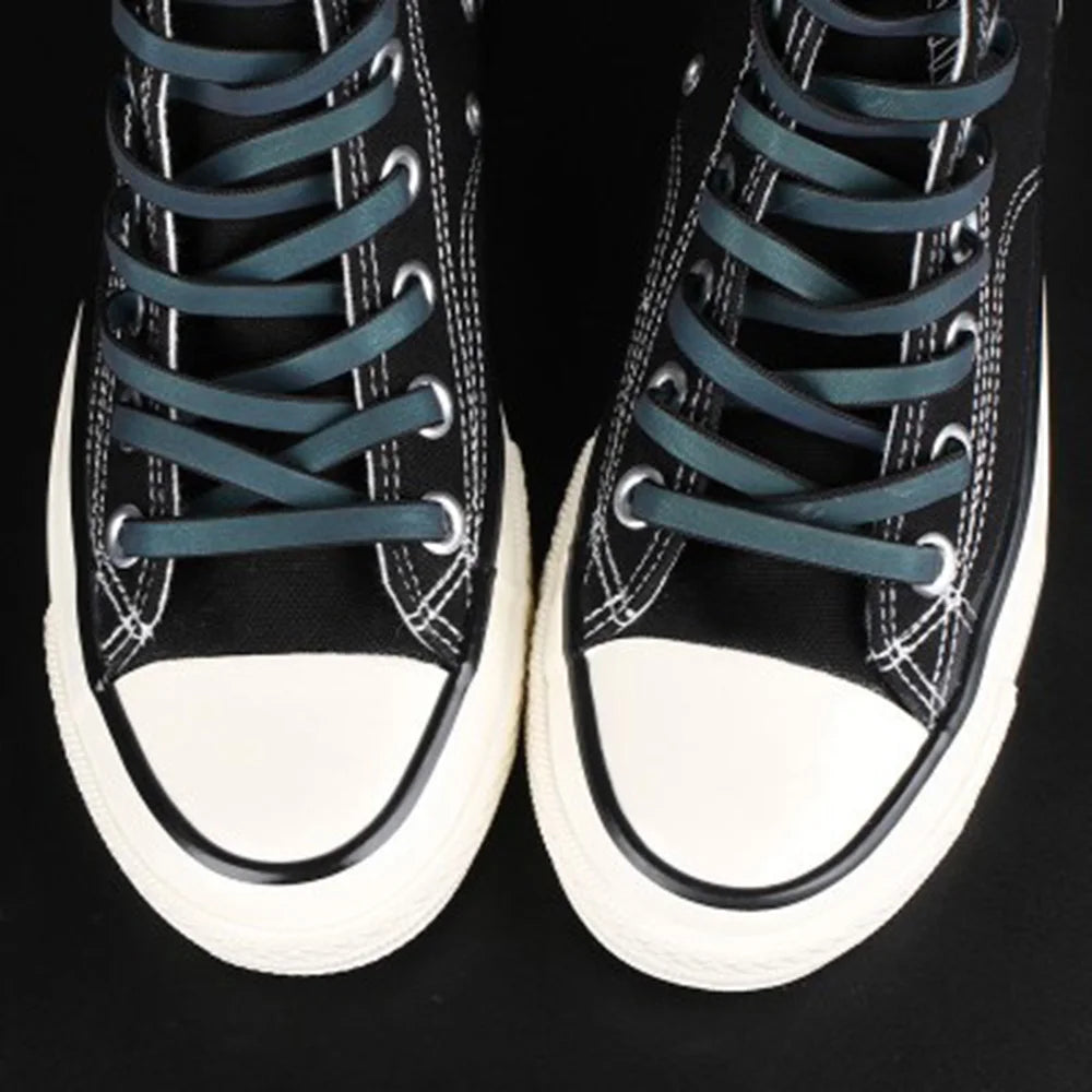 Reflective flat laces in black high-top sneakers in daylight