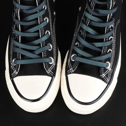 Reflective flat laces in black high-top sneakers in daylight