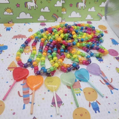 Rainbow kandi necklaces with jelly lollipop heart charms laid flat