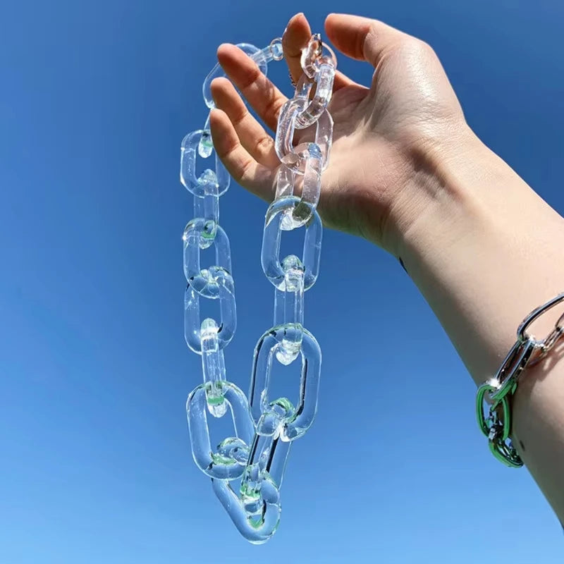 Transparent oversized link chain held up against a blue background