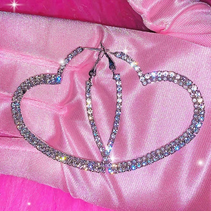 Pair of crystal heart hoop earrings on pink satin