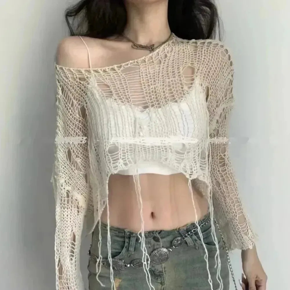 Cream shredded knit crop sweater layered over a tank