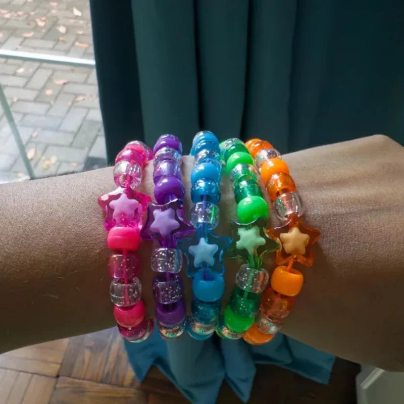 Stacked rainbow star kandi bracelets on forearm