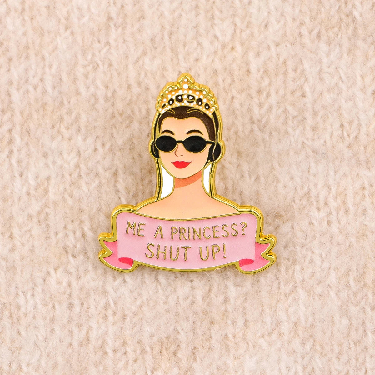 Enamel pin on a cream knit sweater