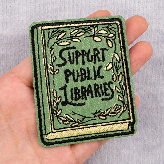 Support Public Libraries embroidered book patch held in hand