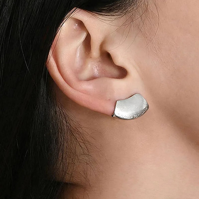 Brushed silver sculptural stud worn on ear