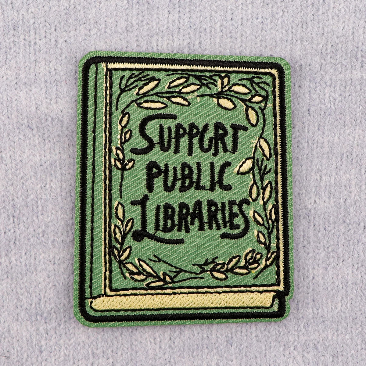 Embroidered book patch on grey knit