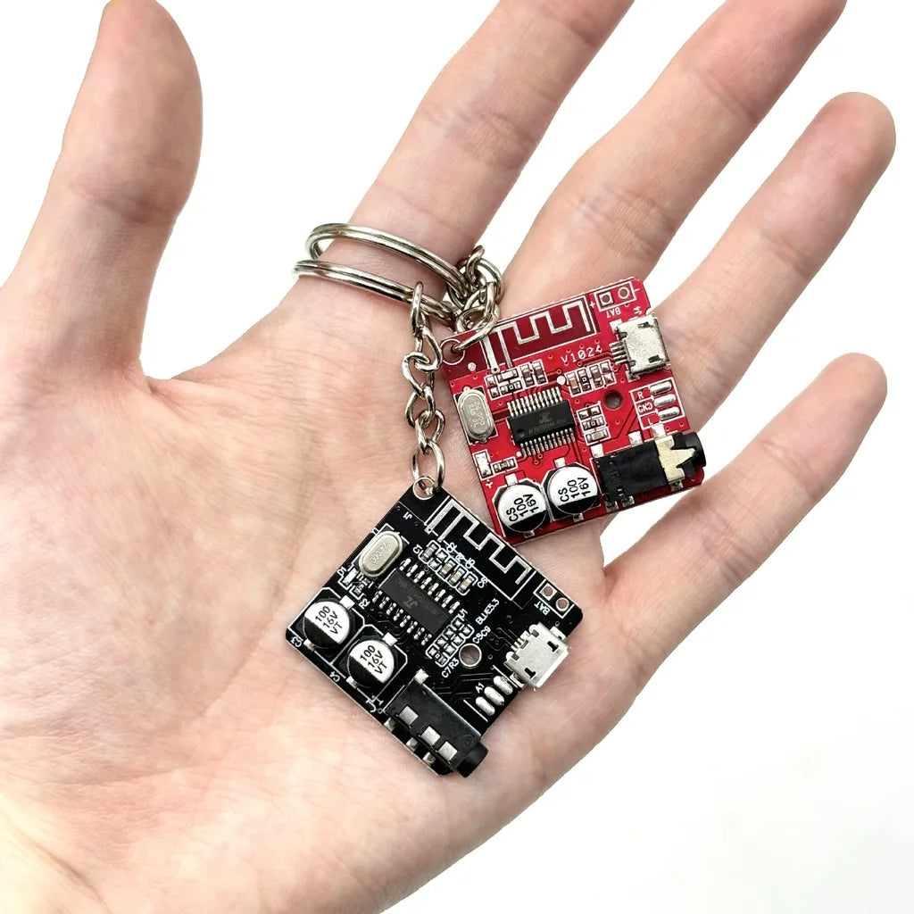 Circuit board keychains held in hand for scale