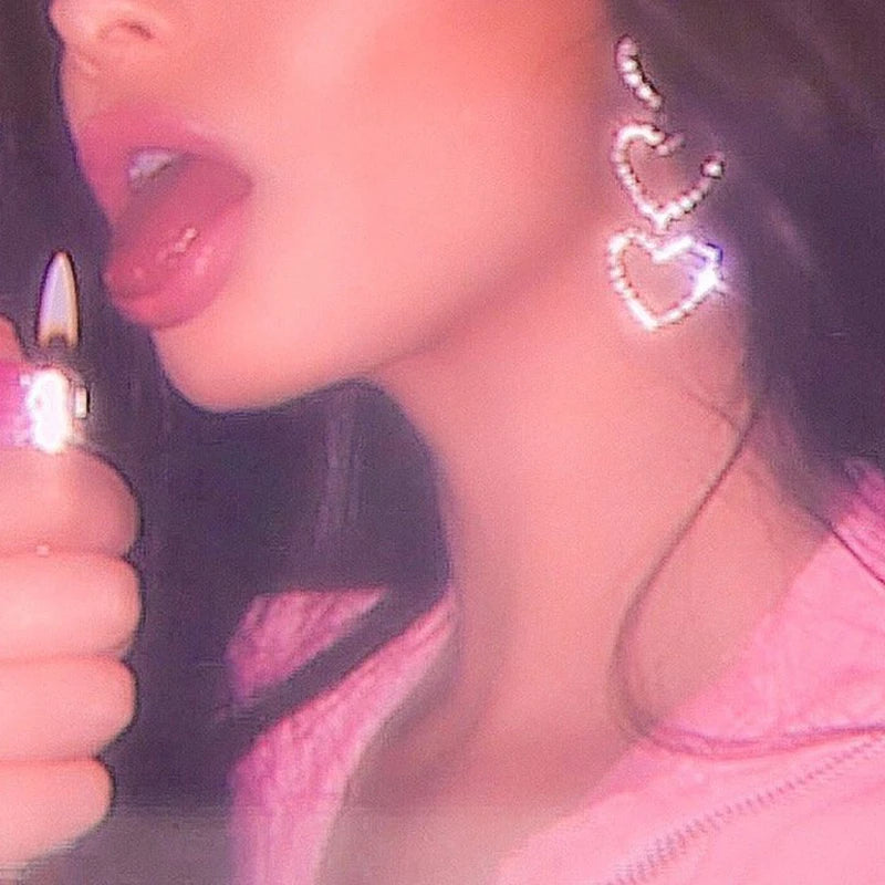 Model wearing rhinestone heart drop earrings