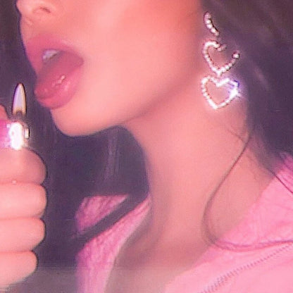 Model wearing rhinestone heart drop earrings
