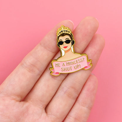 Enamel pin held in hand for scale