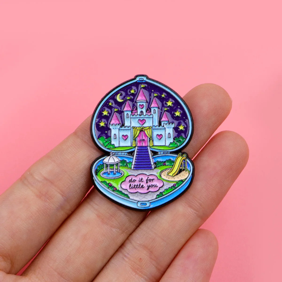 Enamel pin held in a hand to show its scale