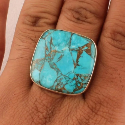 Faux turquoise statement ring worn on the hand