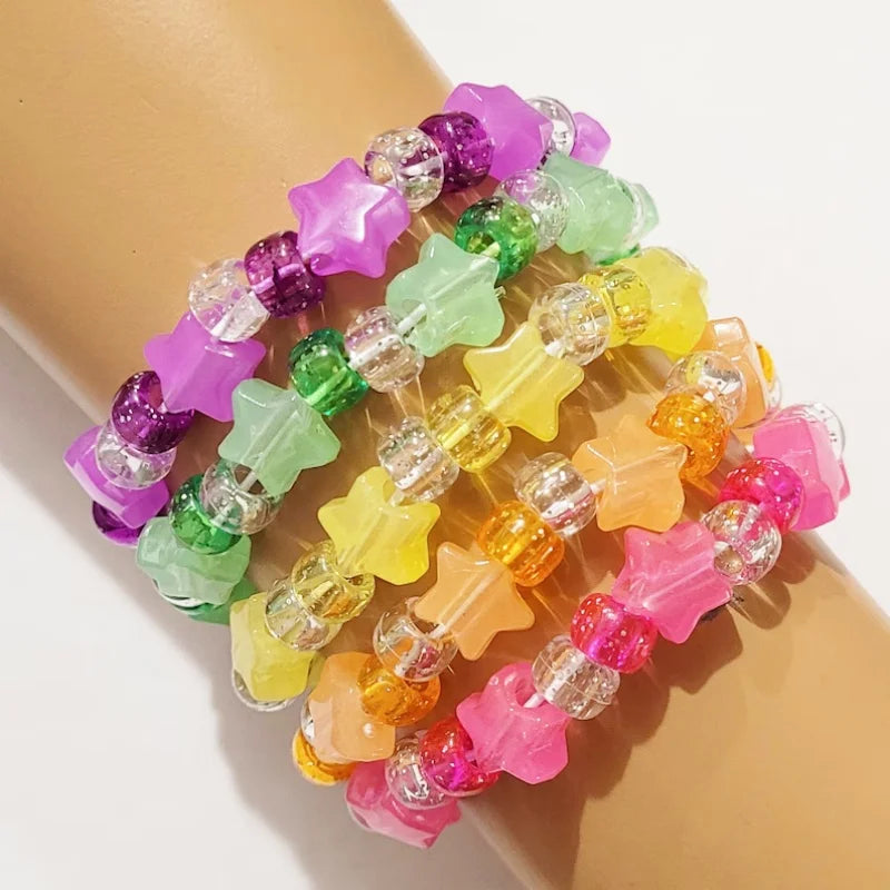 Glitter star kandi bracelets stacked on a wrist