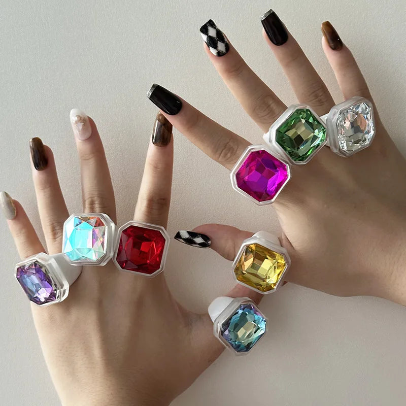 Faceted cocktail rings stacked across both hands
