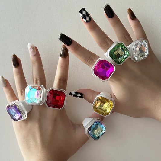 Faceted cocktail rings stacked across both hands