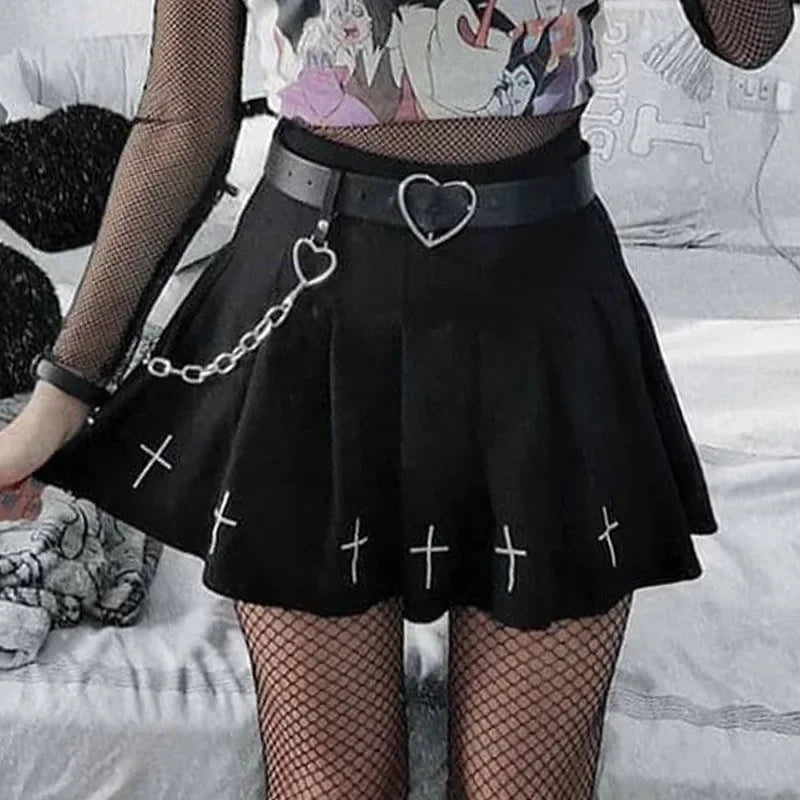 Pleated mini skirt styled with a chain belt and fishnets
