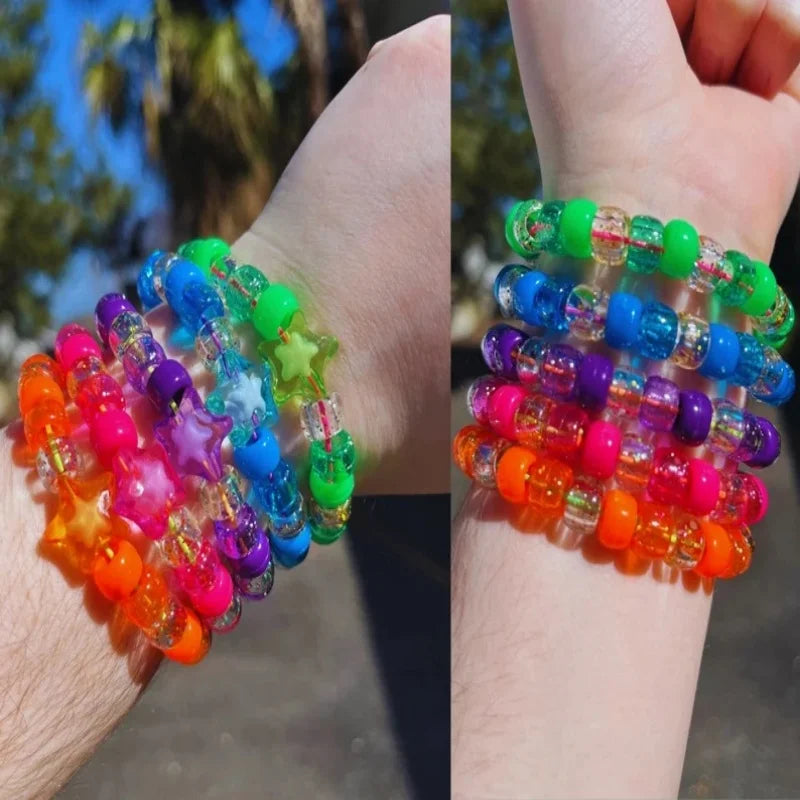 Kandi bracelet stack shown on two wrists outdoors