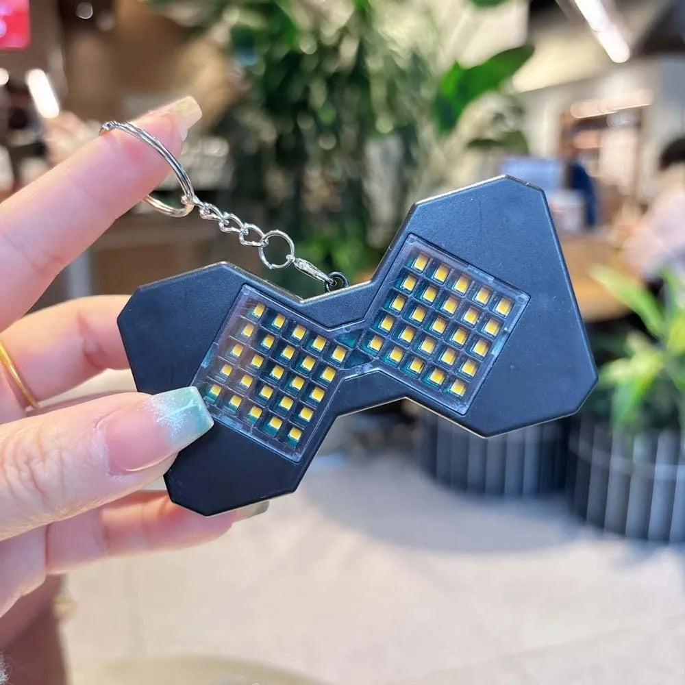 Black LED hourglass keychain held up glowing