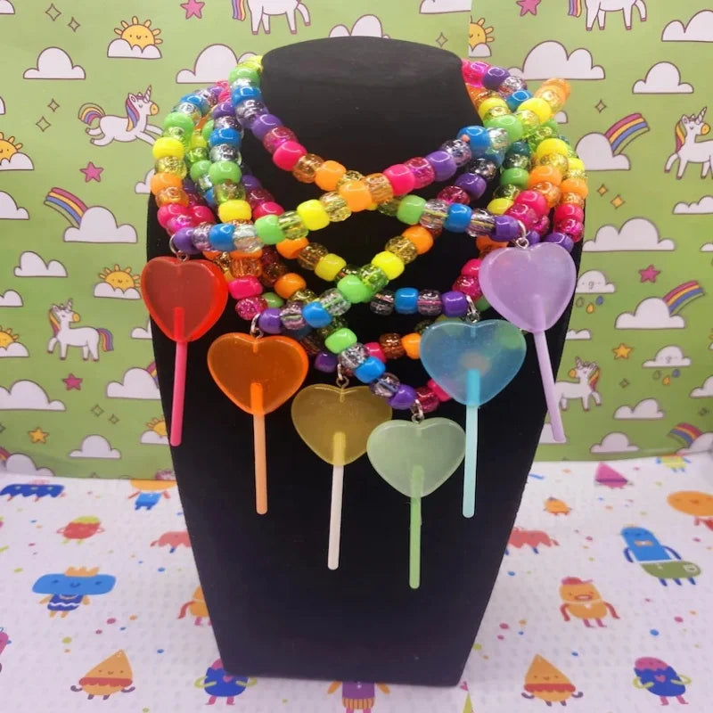Sugar Crash kandi lollipop charm necklaces layered on a display bust