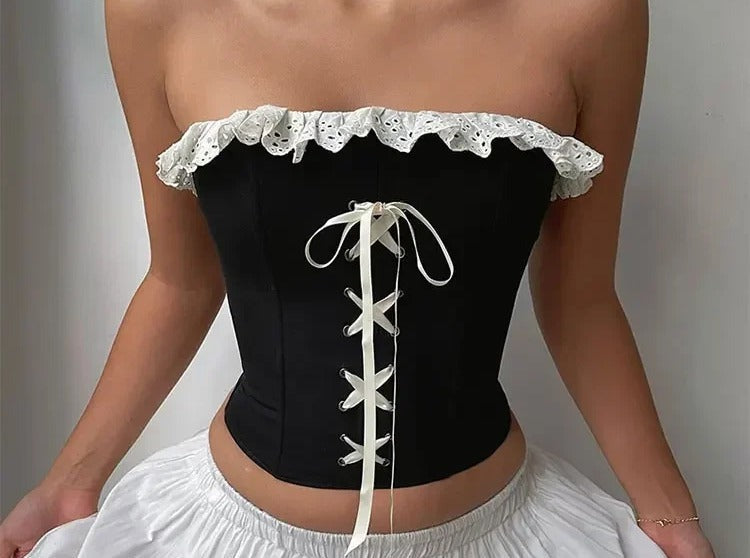 Black corset top with ivory eyelet ruffle trim and cream ribbon lace up front