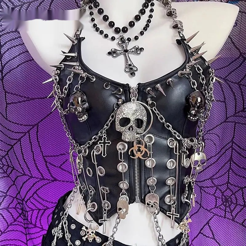 Front view of a black vegan leather corset top with silver-tone spikes, draped chain and skull medallion