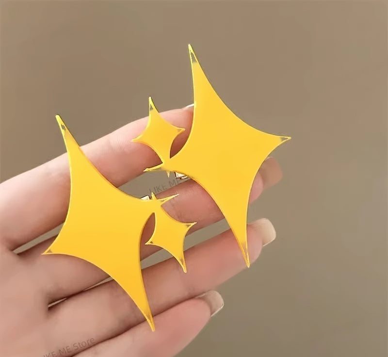 Yellow sparkle hair clips resting on an open palm